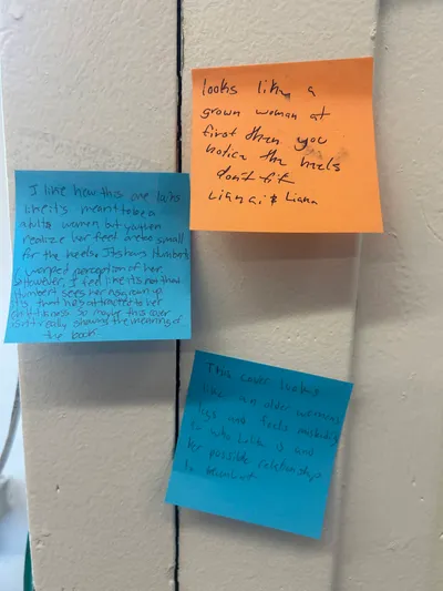 More handwritten sticky-note responses on a wall, students debating whether a book cover misleads the reader about the character's age