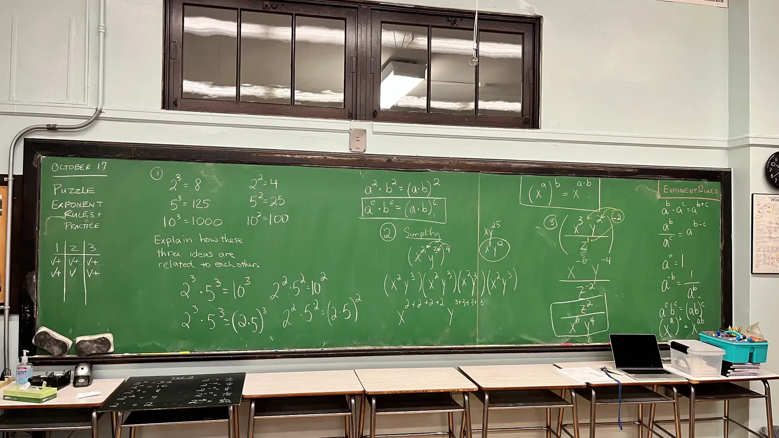 A classroom chalkboard filled with a worked exponent-rules puzzle in a teacher's handwriting, asking students to explain how three ideas relate to each other