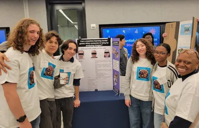 Students and a teacher in matching science-fair T-shirts standing together in front of a research poster asking whether a machine learning model can detect lying from images